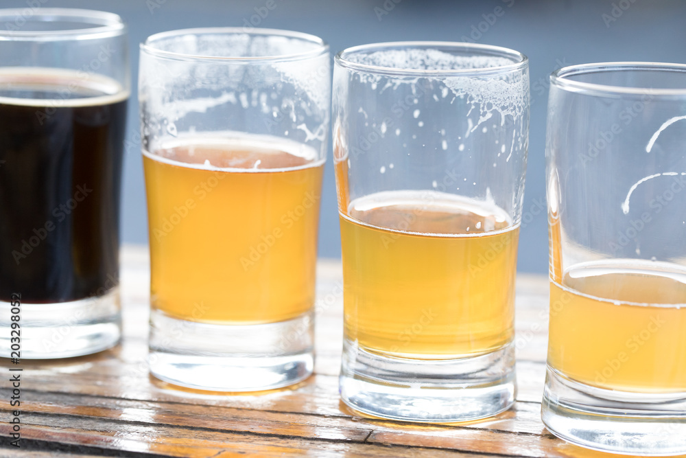 Row of pint glasses with decreasing volumes of of beer Row of pint glasses with decreasing volumes of of beer