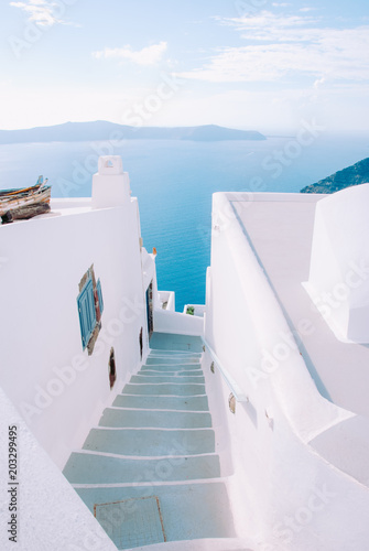 Narrow street on the island of Santorini with steps going down to the sea.