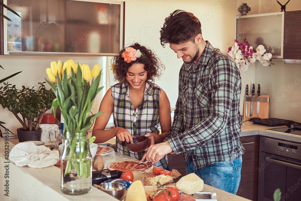 Beautiful young couple cooking in the kitchen at home. Beautiful young couple cooking in the kitchen at home.