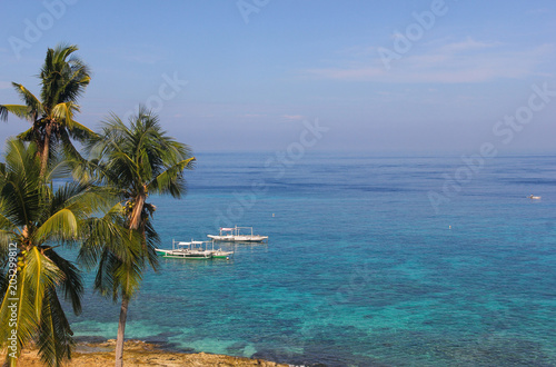 Traditional banka boats on peaceful turquoise water in Apo Island  Philippines. Paradise travel destination  summer vacation  relax concept