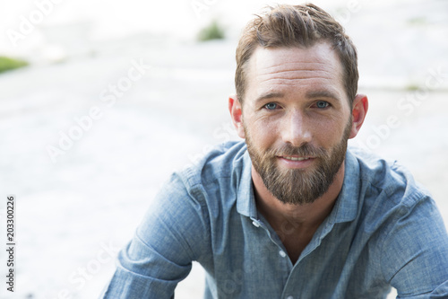 Close-up portrait of smiling man sitting outdoors photo