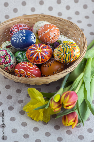 Homemade handmade painted Easter eggs on wicker basket, traditional handcraft eggs