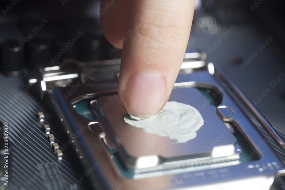 Applying thermal paste with finger in CPU on motherboard