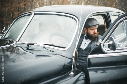 Couple in love on romantic date. Travel and business trip or hitch hiking. Escort of girl by security. Bearded man and sexy woman in car. Retro collection car and auto repair by mechanic driver. © Volodymyr