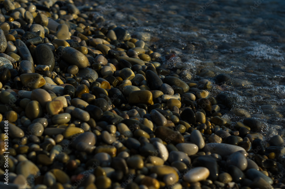 pebble stones on the sea beach, the rolling waves of the sea with foam pebble stones on the sea beach, the rolling waves of the sea with foam