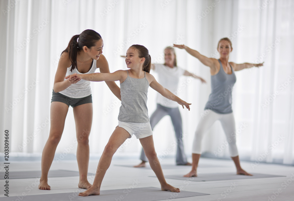 Group of people stretching while doing yoga. Group of people stretching while doing yoga.