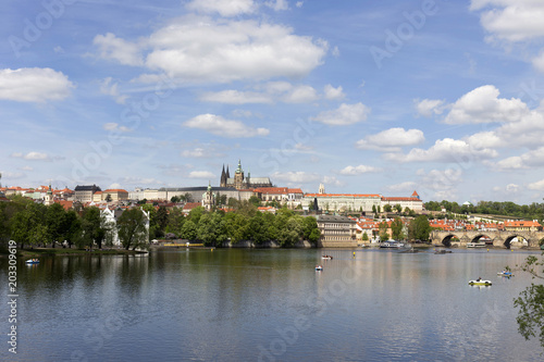Spring green Prague Lesser Town with gothic Castle and Charles Bridge above River Vltava in the sunny Day, Czech Republic