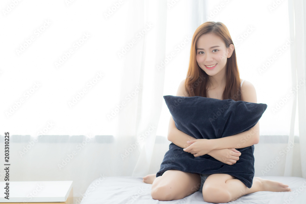 Portrait beautiful young asian woman sitting and smile hug pillow with the window at bedroom while wake up with sunrise at morning, lifestyle and relax concept. Portrait beautiful young asian woman sitting and smile hug pillow with the window at bedroom while wake up with sunrise at morning, lifestyle and relax concept.