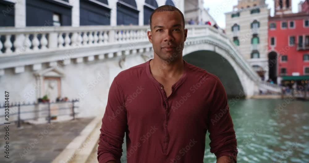 African man traveling in Venice, Italy posing for the camera near the Rialto Bridge, Handsome African-American male looking at the camera confidently in Venice, 4k African man traveling in Venice, Italy posing for the camera near the Rialto Bridge, Handsome African-American male looking at the camera confidently in Venice, 4k