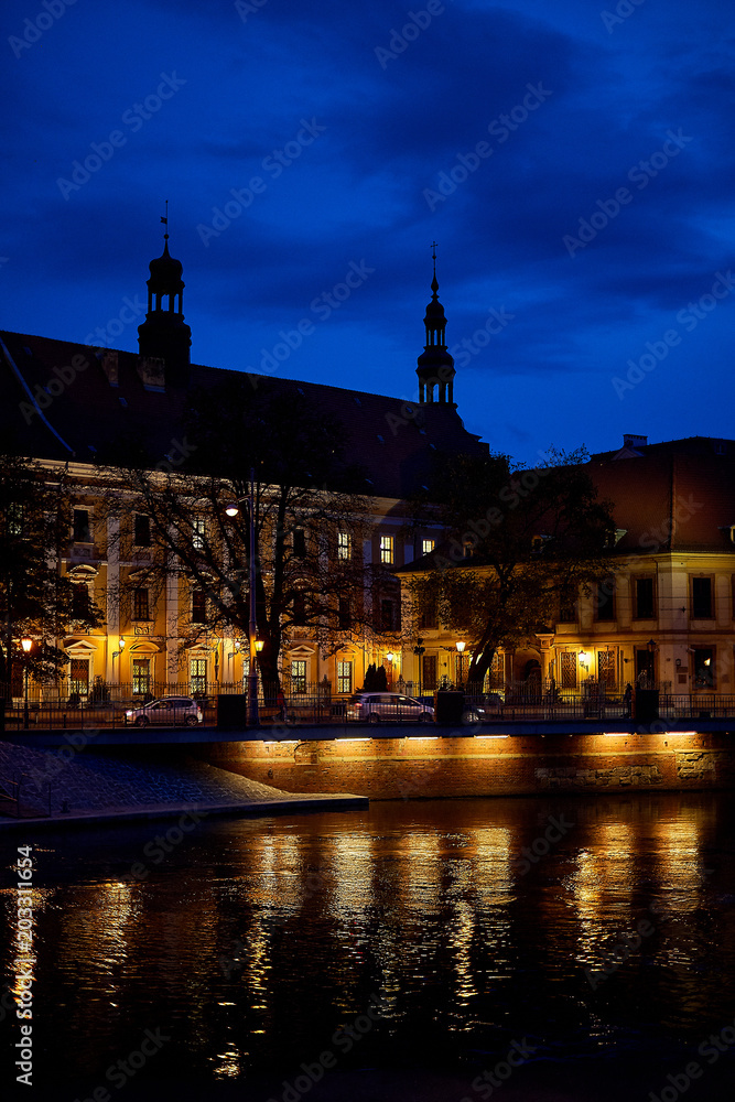 Odra River in a beautiful old city of Wroclaw, Poland with illumination of vintage night lanterns on the Tumsky Island.