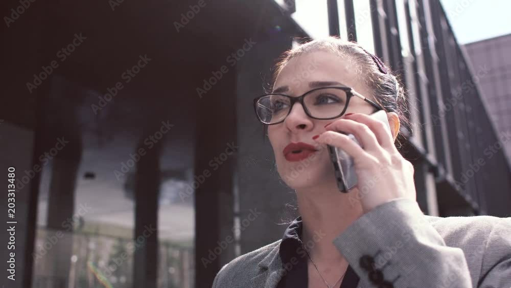 A positive business woman goes to work and talks on the phone. 4k A positive business woman goes to work and talks on the phone. 4k