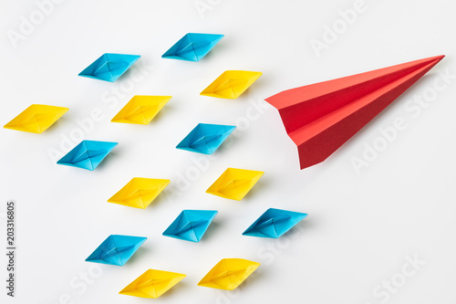Free Download Leadership, influencer, KOL, key opinion leader concept, big red paper plane origami fly lead in front of colorful small yellow and blue paper ship fleet on white background - GFXLoad