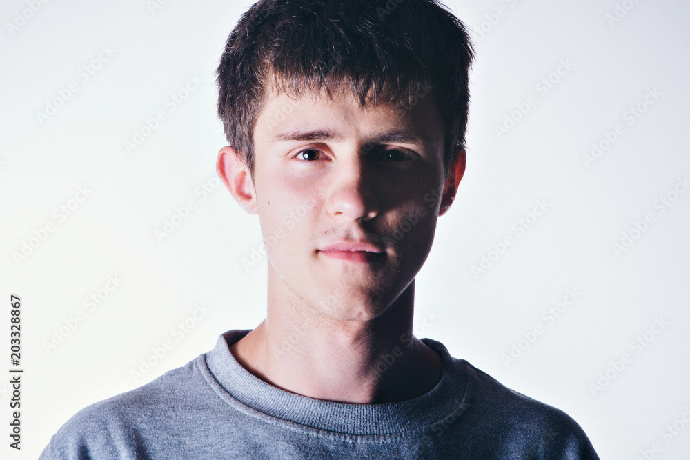 Fototapeta premium Face of handsome man with fashionable hairstyle half closed in shadow