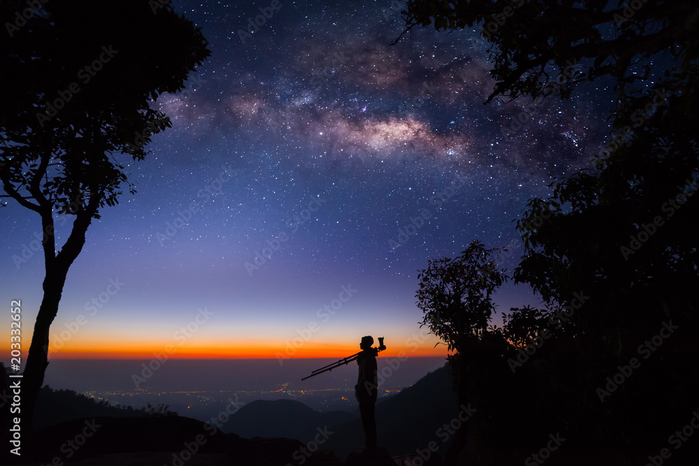 Silhouette of a Professional photographer shooting a milky way