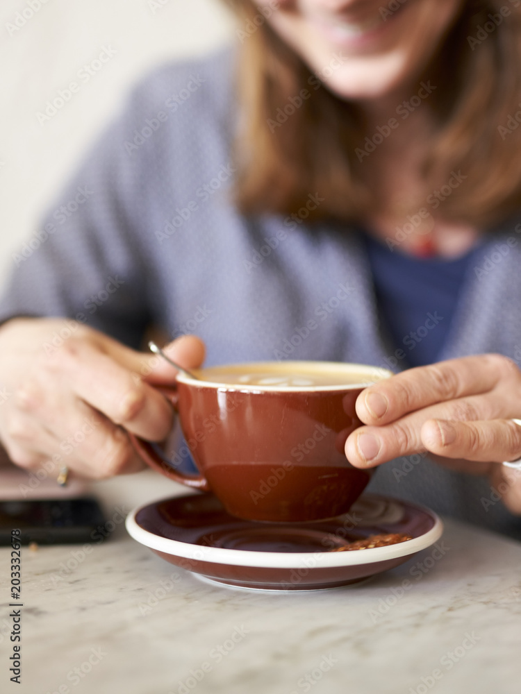 Woman holding a cafe latte in hand