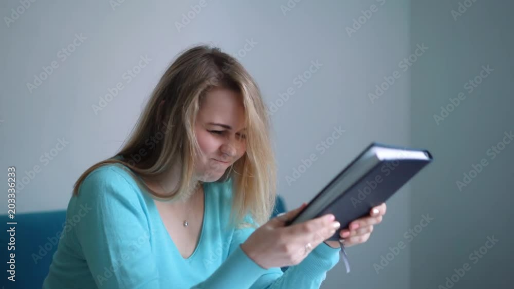 Female student studying and reading in a library but is having a hard time understanding the material