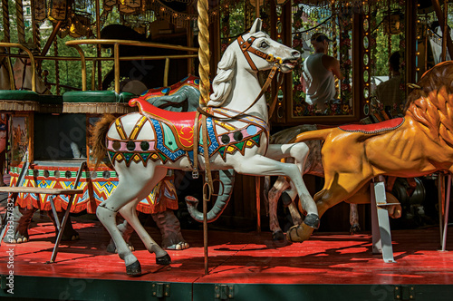 Colorful carousel with white horse in a park of Annecy. An historical and lovely lakeside town located at the department of Haute-Savoie, southeastern France.