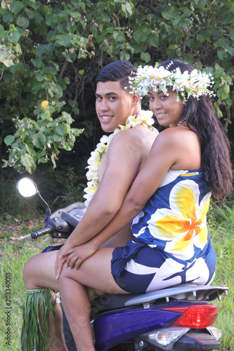 Happy Pacific Islander  honeymoon couple riding motor scooter in Rarotonga Cook Islands photo