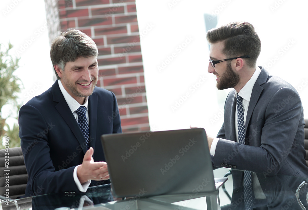 Two businessmen working on a laptop in the office Two businessmen working on a laptop in the office