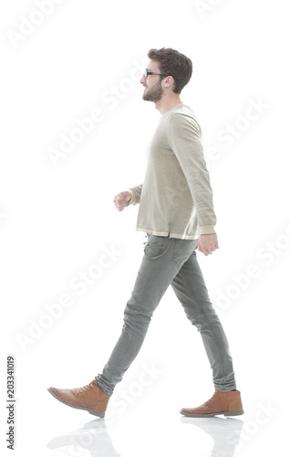 Side view.Young smiling man walking forward