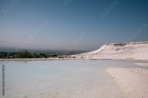 beautiful landscape with white rocks and calm water of pool in pamukkale  turkey