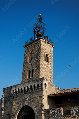 Close-up of old stone tower at sunrise, with clock and bell, in the city center of the quiet village of Le Thor. Located in the Vaucluse department, Provence-Alpes-Côte d'Azur region in southeastern F