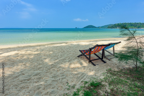Beach chairs on the white sand beach and tropical sea in Thailand. © yotrakbutda