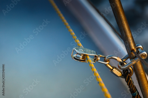 The rigging block with swivel and yellow rope. Part of the rigging of the yacht. Place for text.
