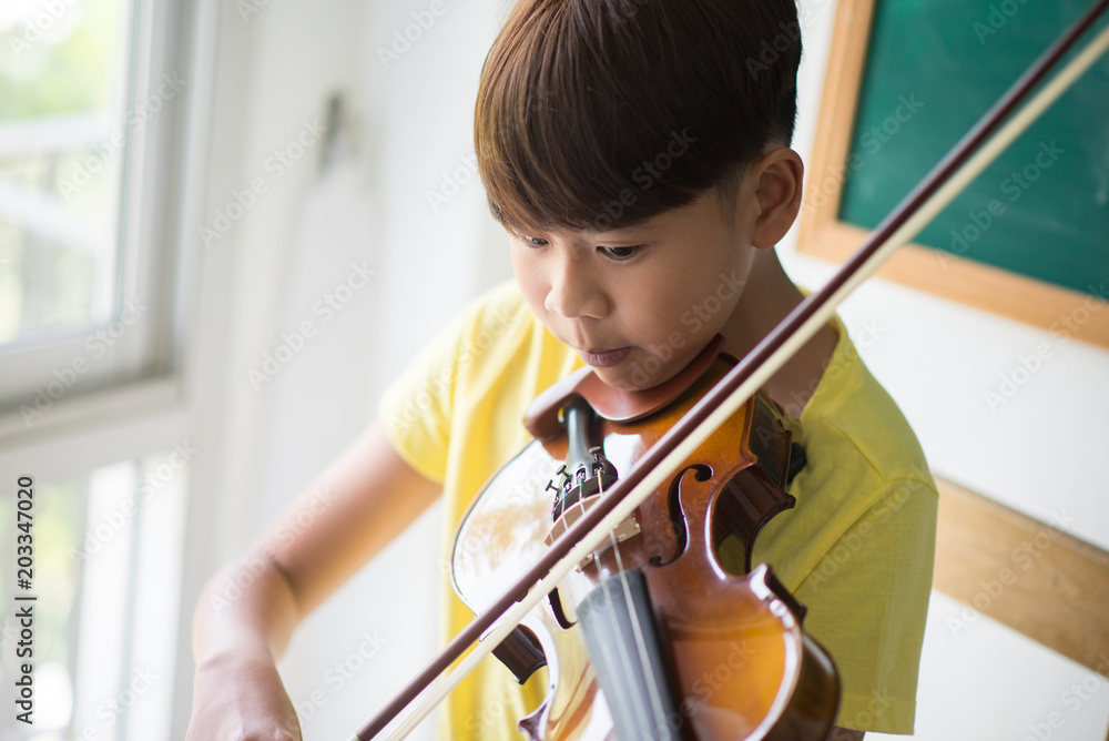 Little boys play and practice violin in the music class room Little boys play and practice violin in the music class room