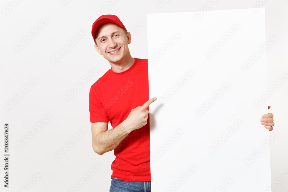 Delivery young man in red uniform isolated on white background. Male courier in cap t-shirt holding big white empty paper billboard. Copy space advertisement. Place for text or image. Advertising area Delivery young man in red uniform isolated on white background. Male courier in cap t-shirt holding big white empty paper billboard. Copy space advertisement. Place for text or image. Advertising area