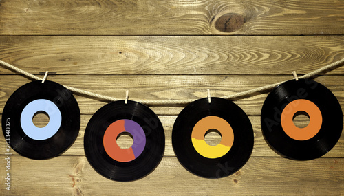 four vinyl singles on wood with string