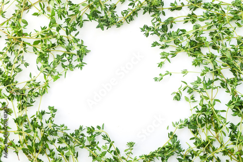 Thyme leaves and twigs arranged in frame form with text space on white background