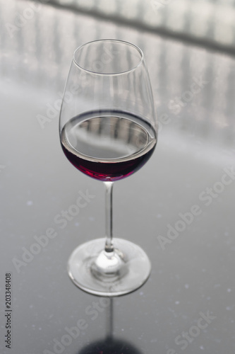 Wineglass with red wine on black table