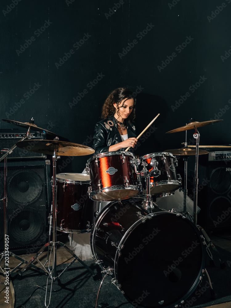 Fototapeta premium Wedding in the style of rock. Guys with stylish leather jackets. It's a rock'n'roll baby Sweet couple in a music studio. The bride plays the drums, and the groom sings.