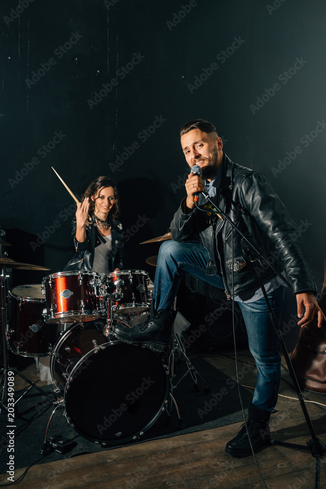 Wedding in the style of rock. Guys with stylish leather jackets. It's a rock'n'roll baby Sweet couple in a music studio. The bride plays the drums, and the groom sings.