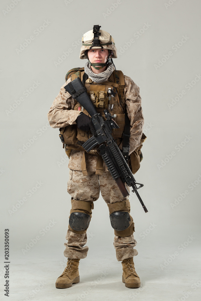 Soldier in camouflage holding rifle Soldier in camouflage holding rifle