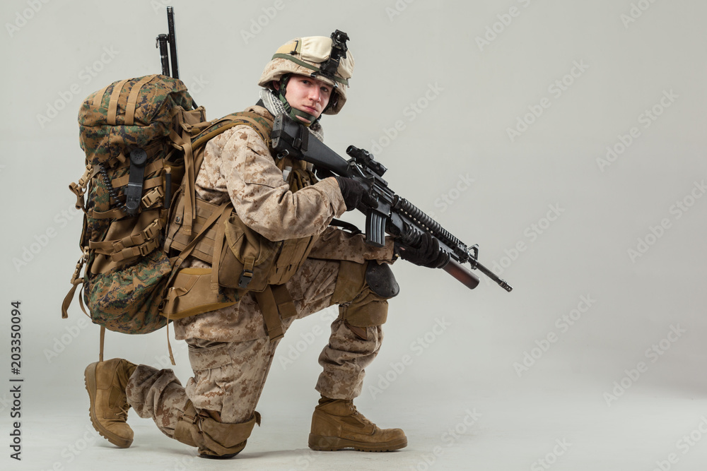 Soldier in camouflage holding rifle Soldier in camouflage holding rifle