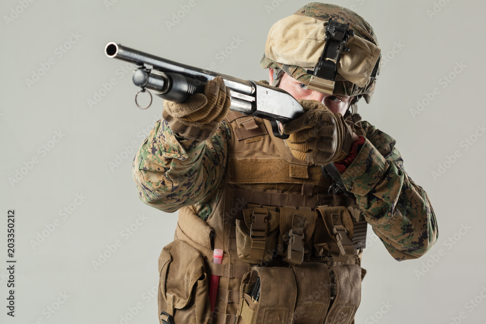 Fototapeta premium Soldier in camouflage holding rifle