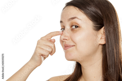 Profile of happy young woman touching her nose on white background