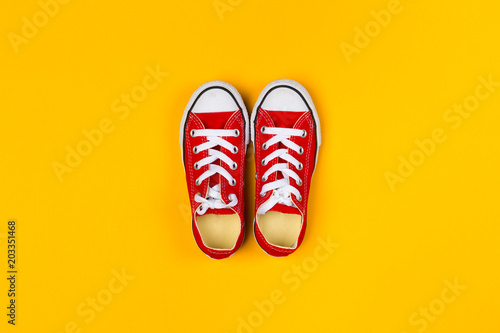 Red sneakers top view close up on colorful background