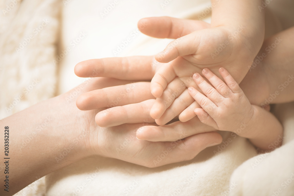Newborn child hand. Closeup of baby hand into parents hands. Family, maternity and birth concept. Newborn child hand. Closeup of baby hand into parents hands. Family, maternity and birth concept.