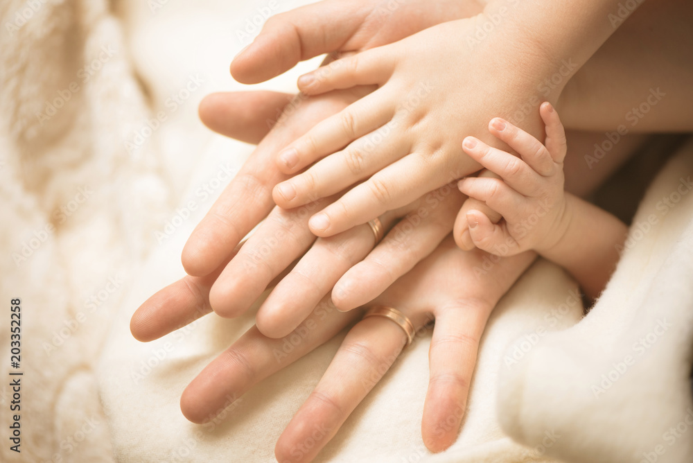 Newborn child hand. Closeup of baby hand into parents hands. Family, maternity and birth concept. Newborn child hand. Closeup of baby hand into parents hands. Family, maternity and birth concept.