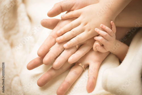 Newborn child hand. Closeup of baby hand into parents hands. Family  maternity and birth concept.