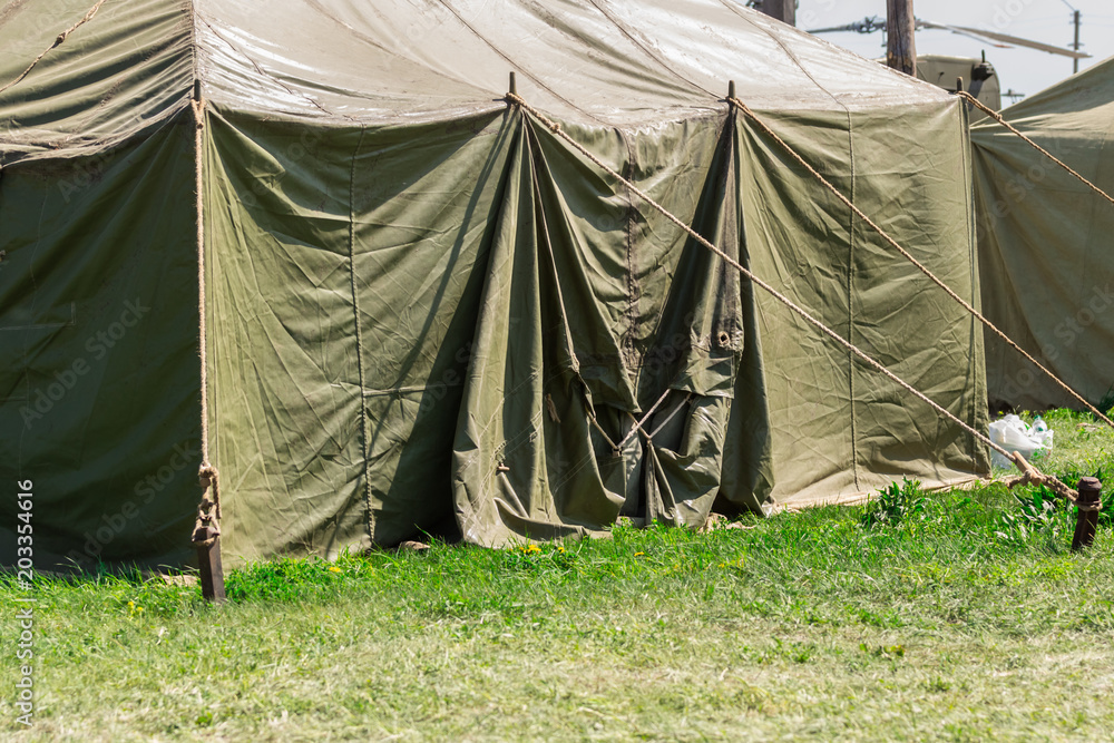 Detail with the exterior of a green military tent. summer