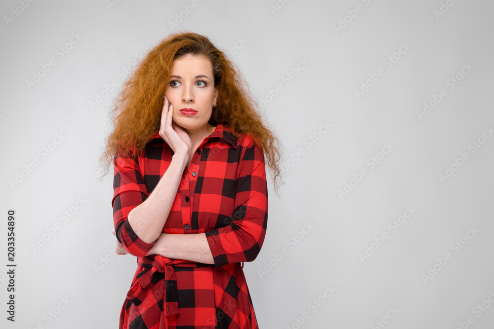 Portrait of beautiful redhead upset frustrated sad young woman on gray background Portrait of beautiful redhead upset frustrated sad young woman on gray background