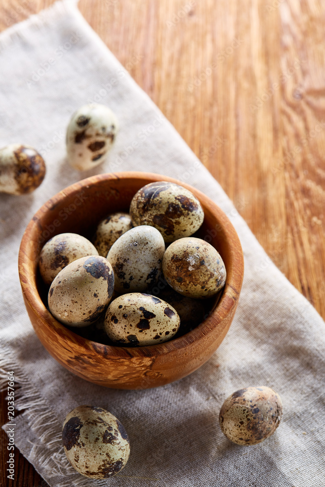Bowl with eggs quail, eggs on a homespun napkin on wooden table, close-up, selective focus Bowl with eggs quail, eggs on a homespun napkin on wooden table, close-up, selective focus