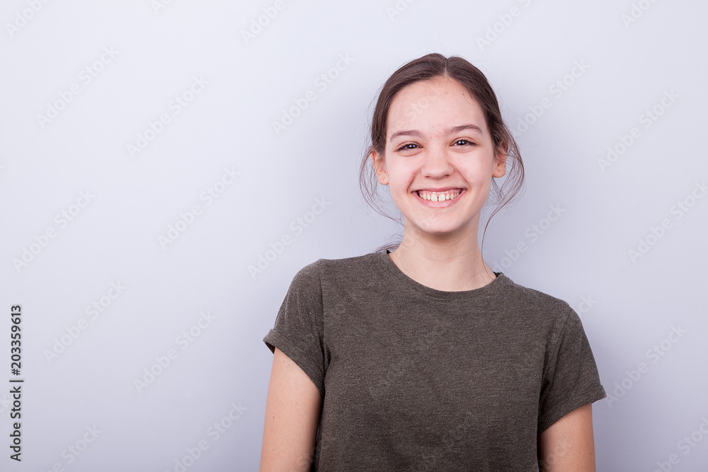 Portrait of smiling happy girl on gray background in studio photo Portrait of smiling happy girl on gray background in studio photo
