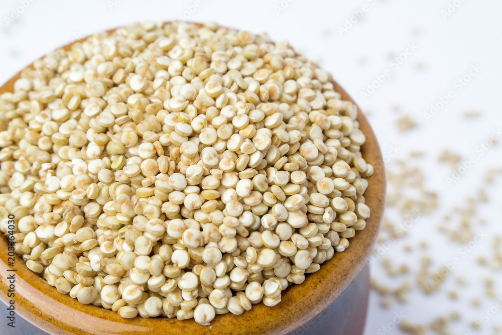 White uncooked quinoa grain in a ceramic bowl, close-up view White uncooked quinoa grain in a ceramic bowl, close-up view