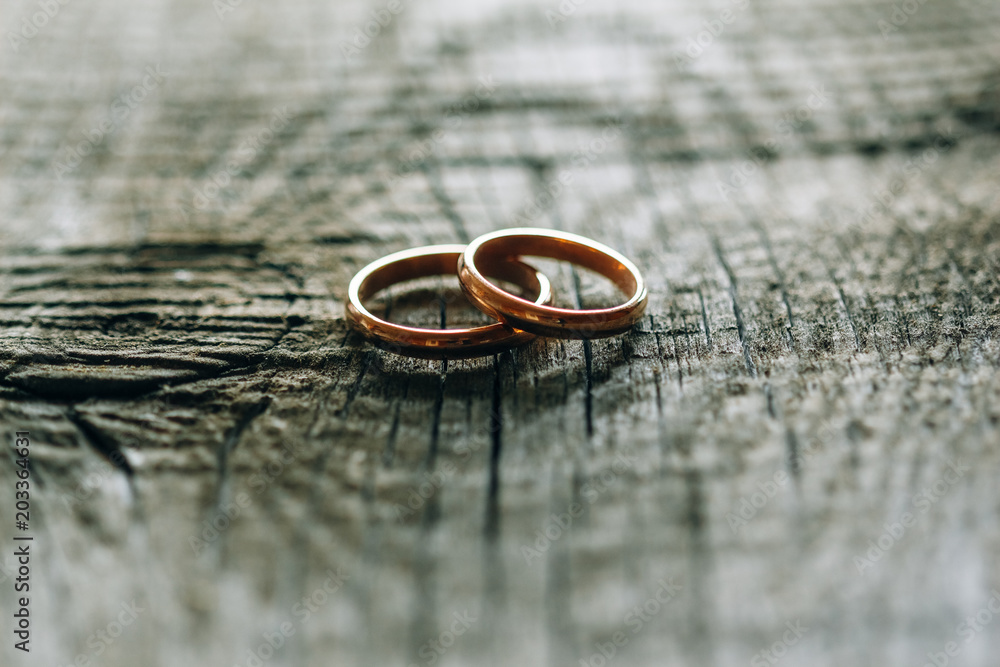 Newlyweds rings closeup on wooden table Newlyweds rings closeup on wooden table