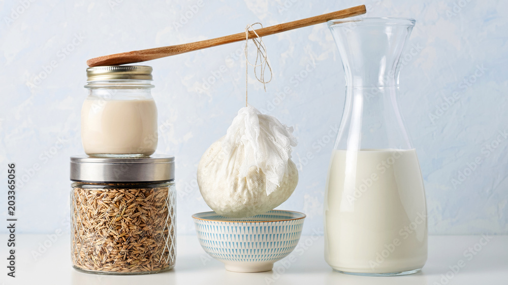 Preparation fresh cottage cheese. The curds in strainer to drain from a wooden spoon between two stacks of glass